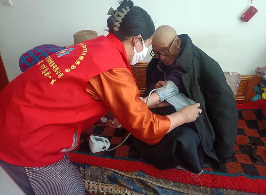 社区志愿者为老年人贴心服务。洛松泽成摄